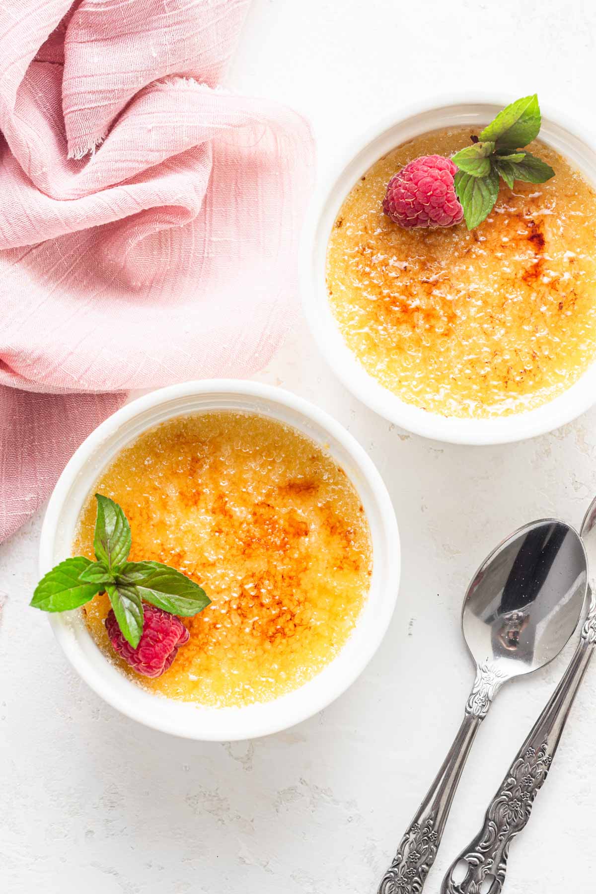 Creme brulee for two on white table.
