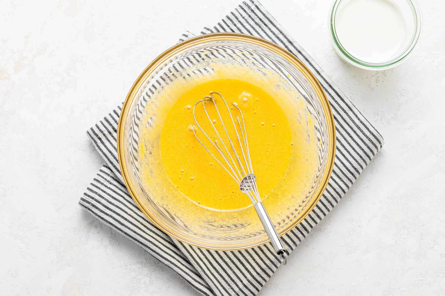 Egg yolks and sugar, whisked together in bowl.