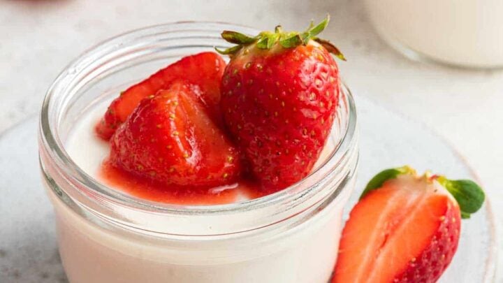 Close up shot of panna cotta recipe for two with strawberries on top.