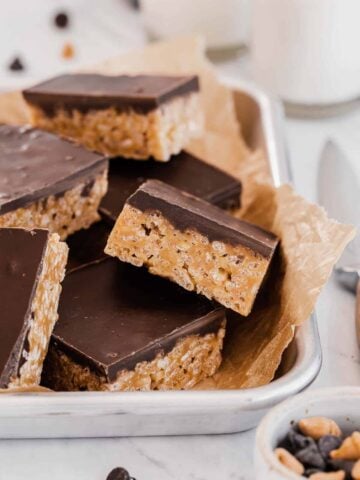 butterscotch rice krispies treats with chocolate on top piled in pan