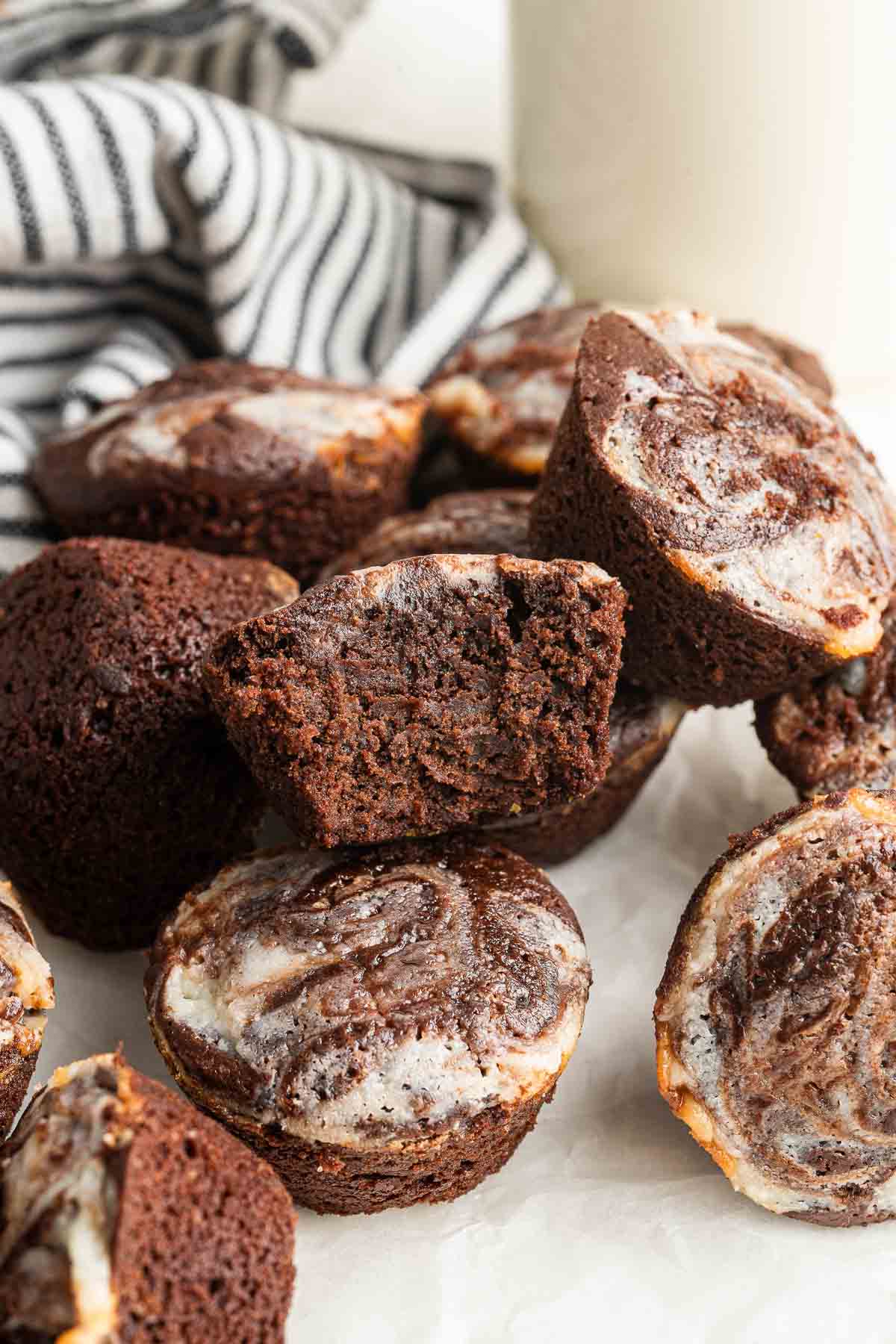 Cheesecake brownie bites piled up with one cut in half to show fudginess inside.