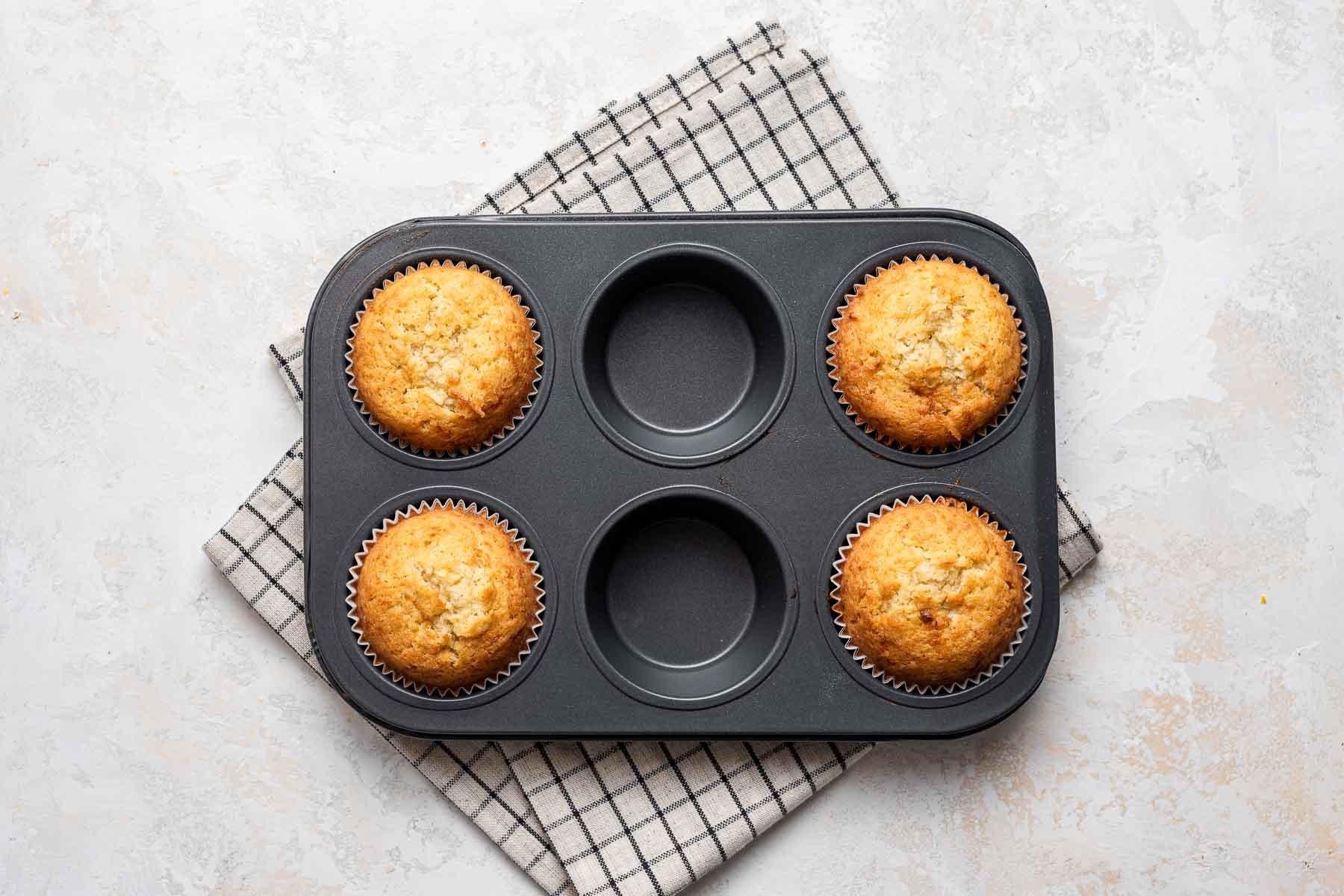 Baked yellow cupcakes in pan.