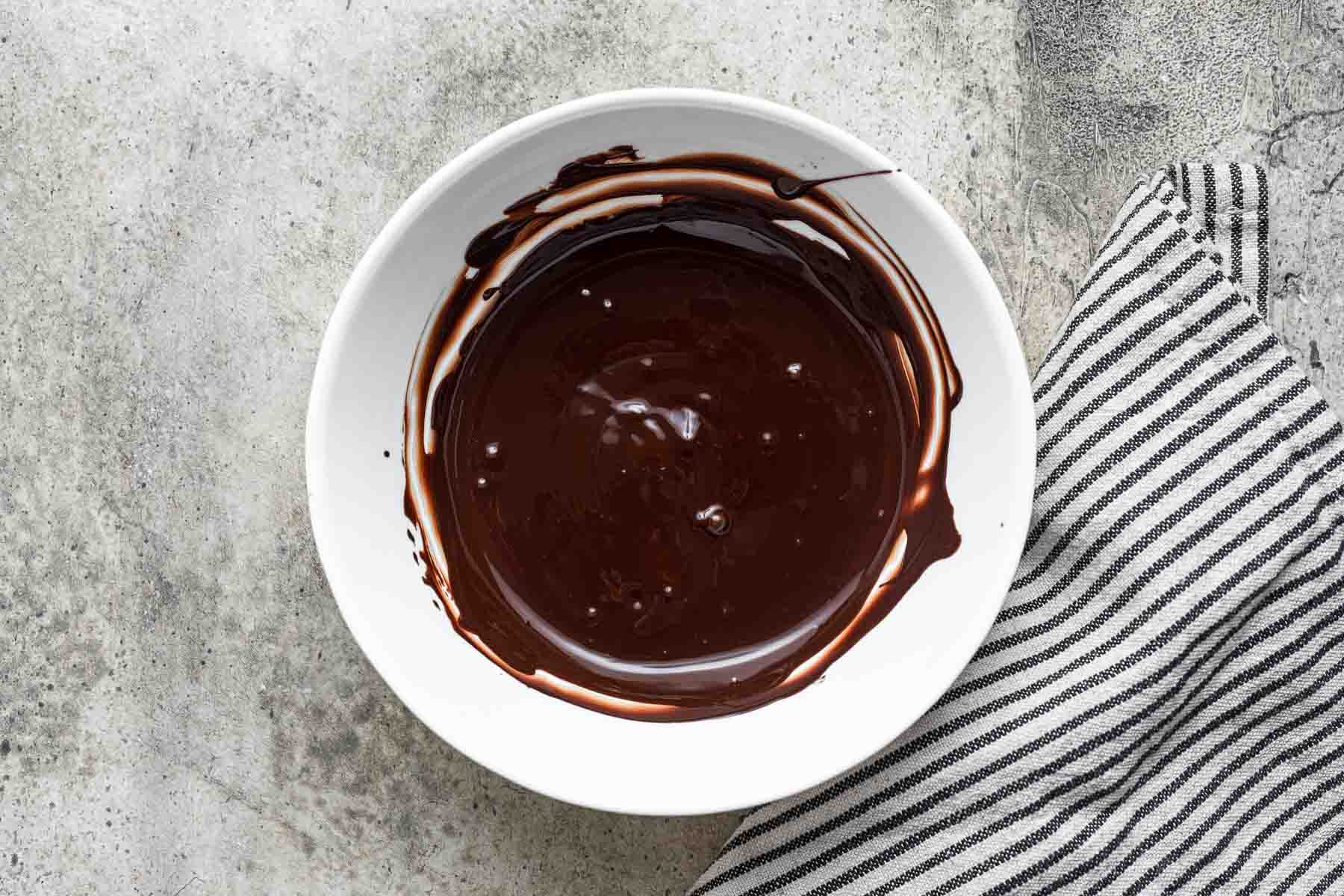 Melted chocolate in small white bowl.