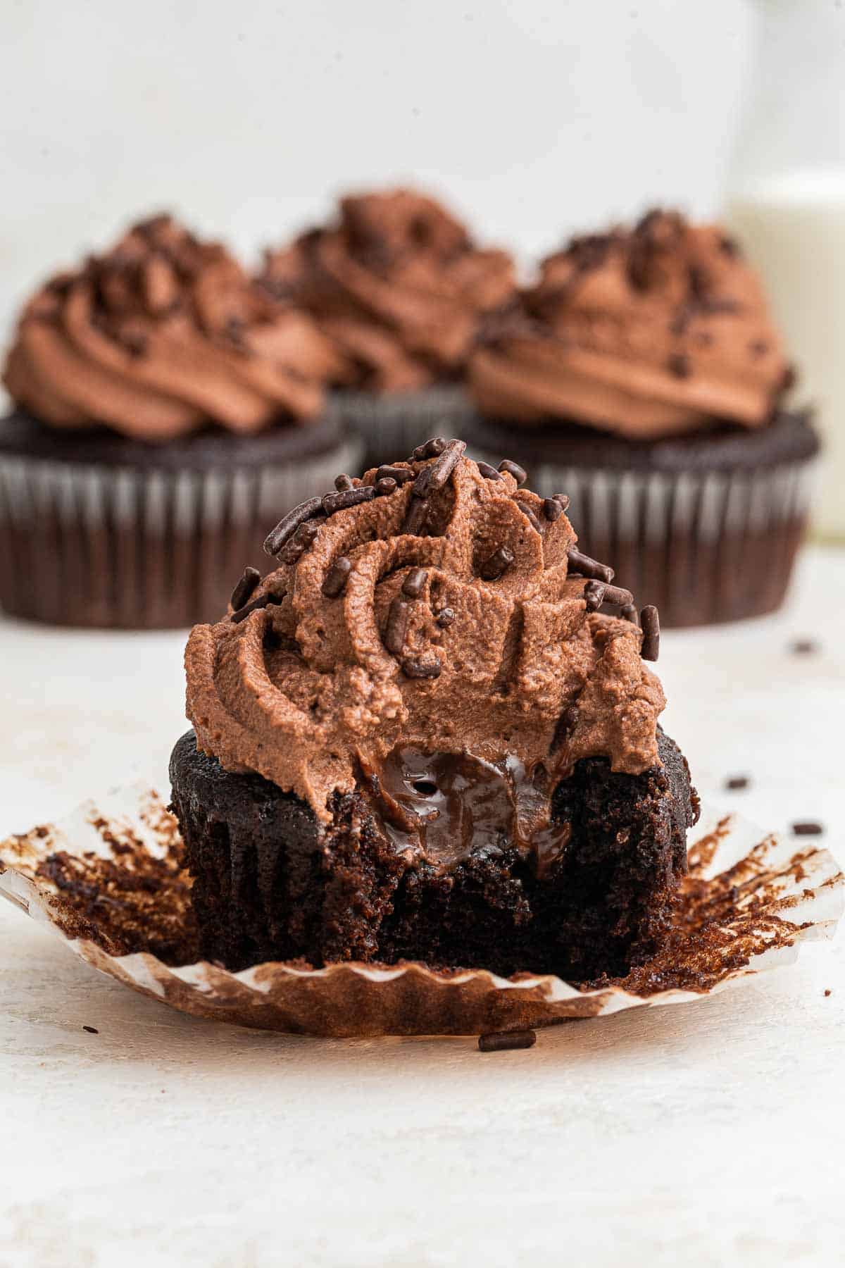 Phot of chocolate cupcake cut in half with swirly chocolate frosting.