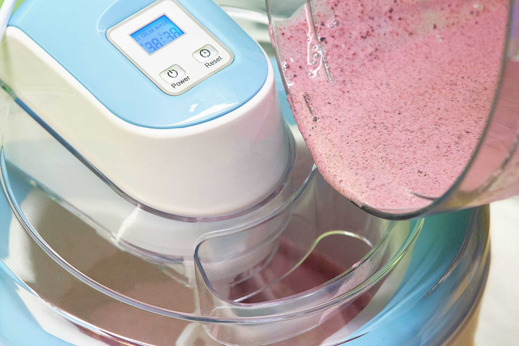Pouring blueberry sorbet into an ice cream maker.