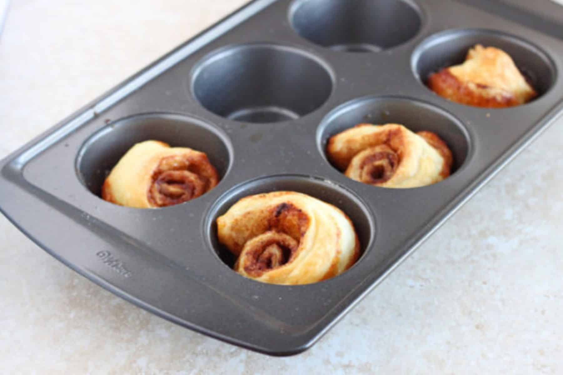 Small batch sticky buns in muffin pan after being baked.
