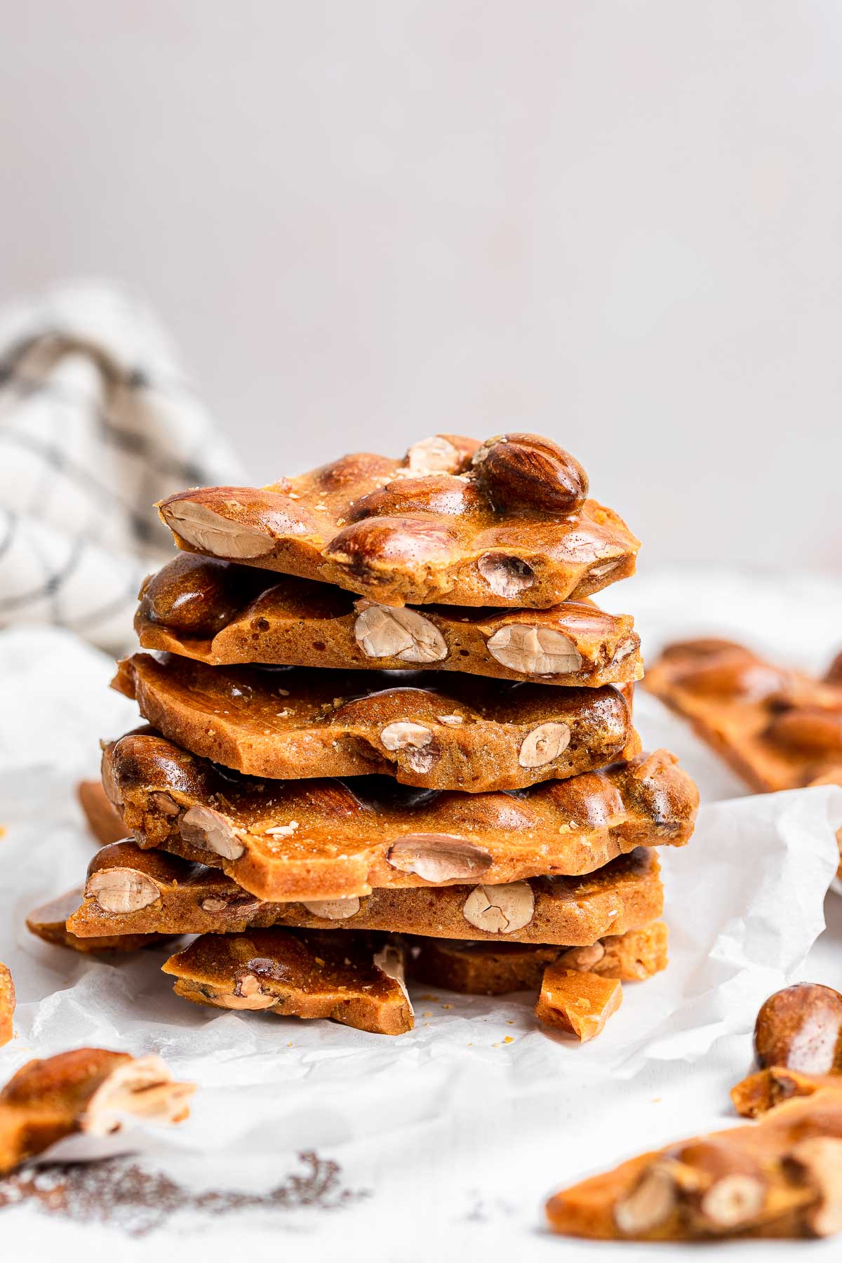 Stack of almond brittle on white table.