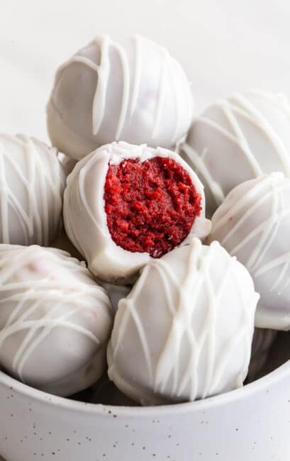 Red velvet cake pops in a white bowl.
