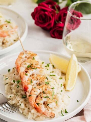 Two plate of lemon risotto with grilled shrimp on top