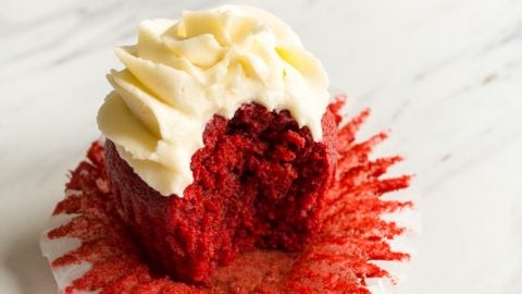 Single red velvet cupcake on a marble table.