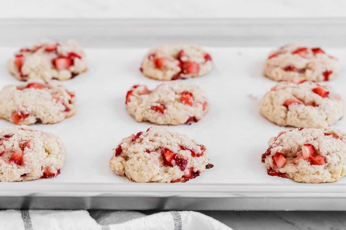 Fresh strawberry cookies on a baking sheet.