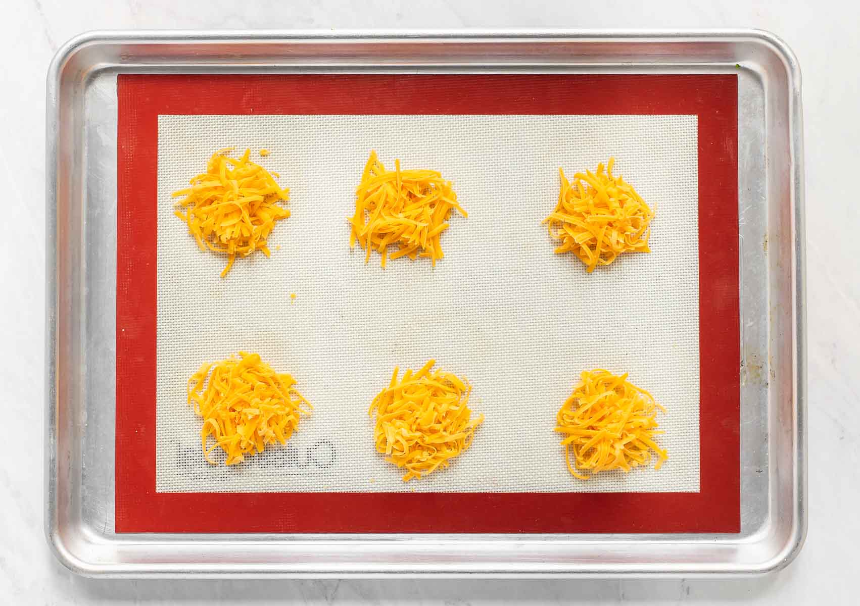 Grated cheddar on a baking sheet.