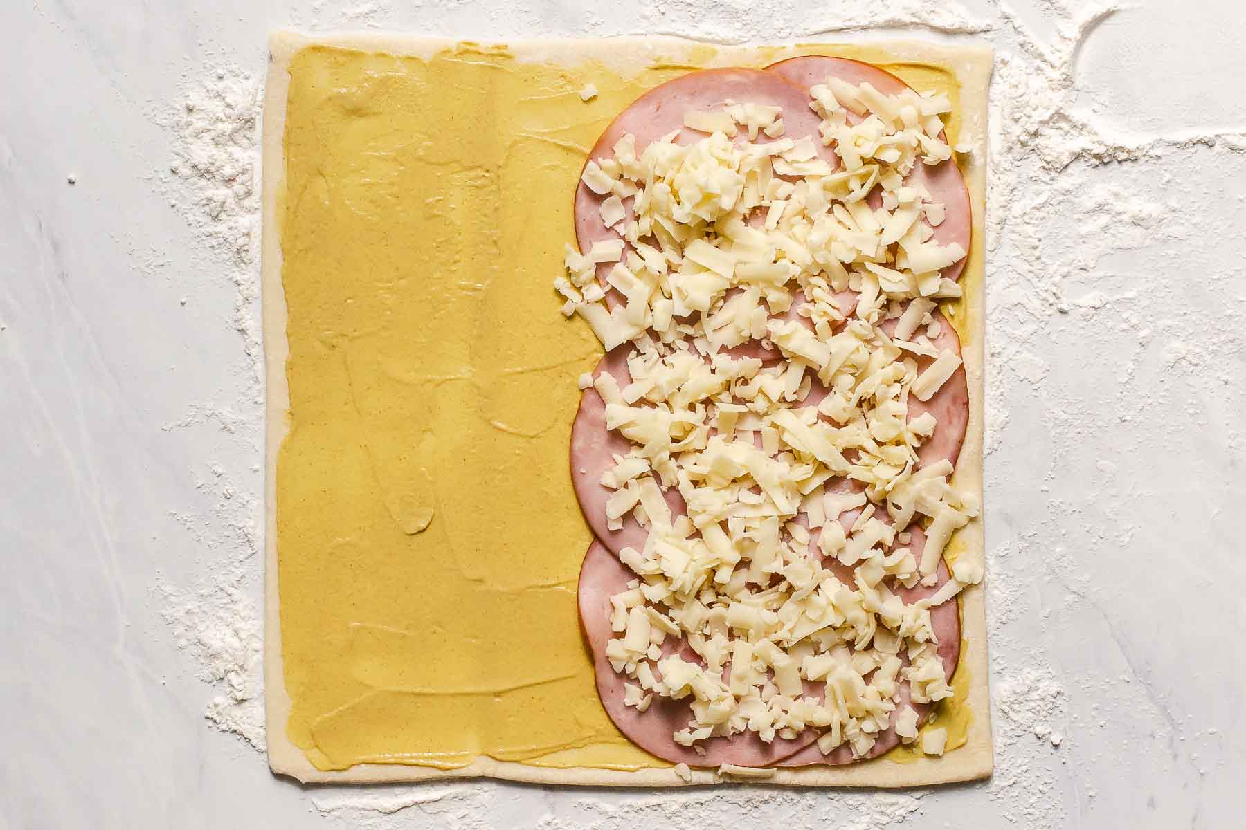Pastry with ham and cheese on half.