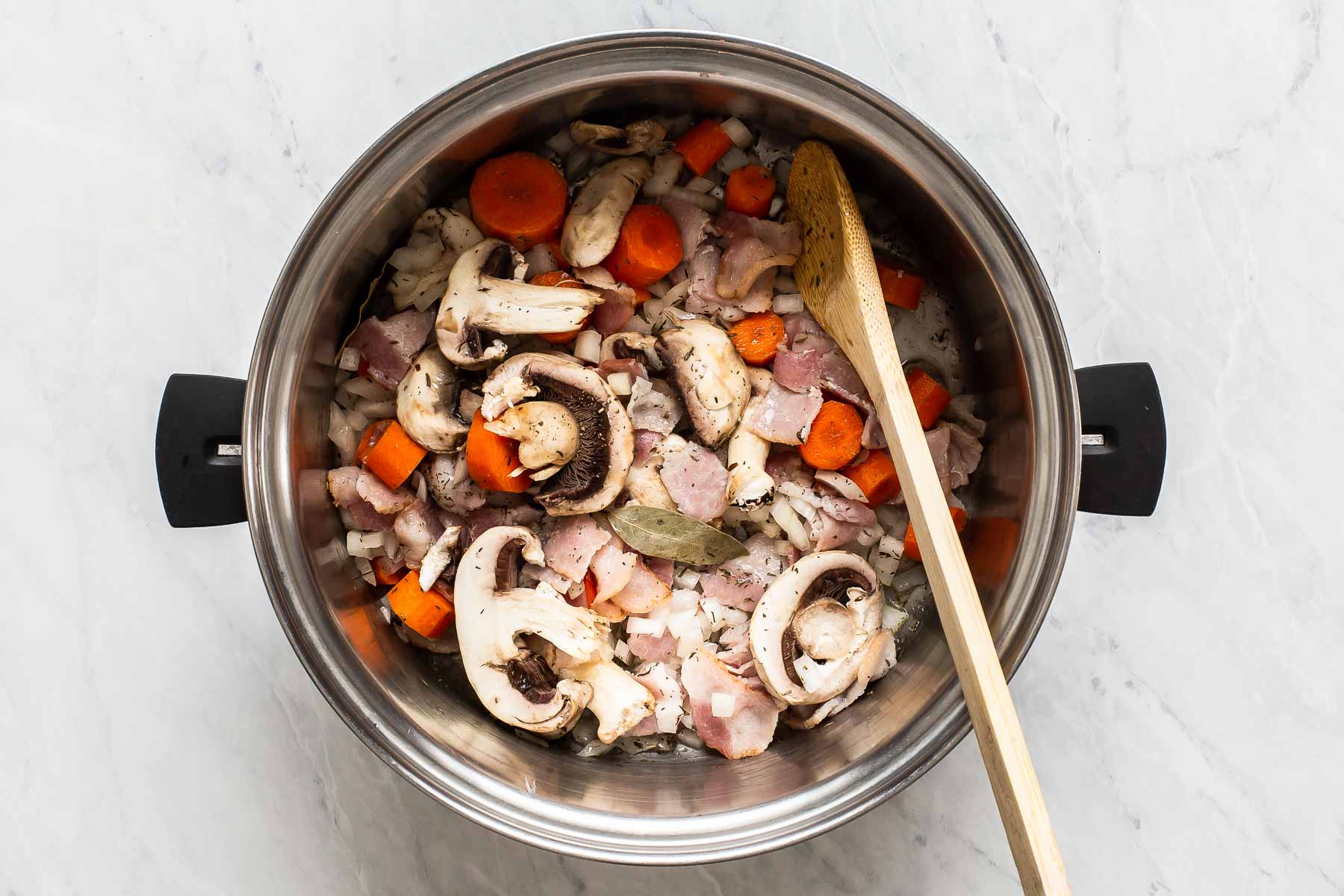 Mushrooms, carrots, onion, cooking in a stockpot.