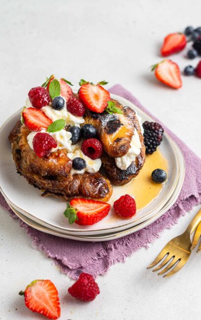Croissant French toast with whipped cream and fresh berries.
