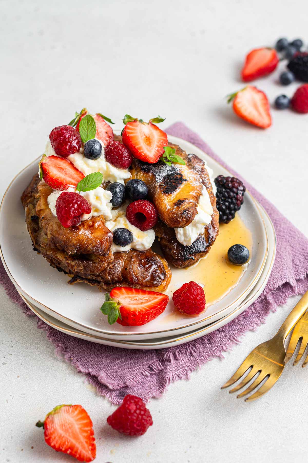 Croissant French toast with whipped cream and fresh berries.