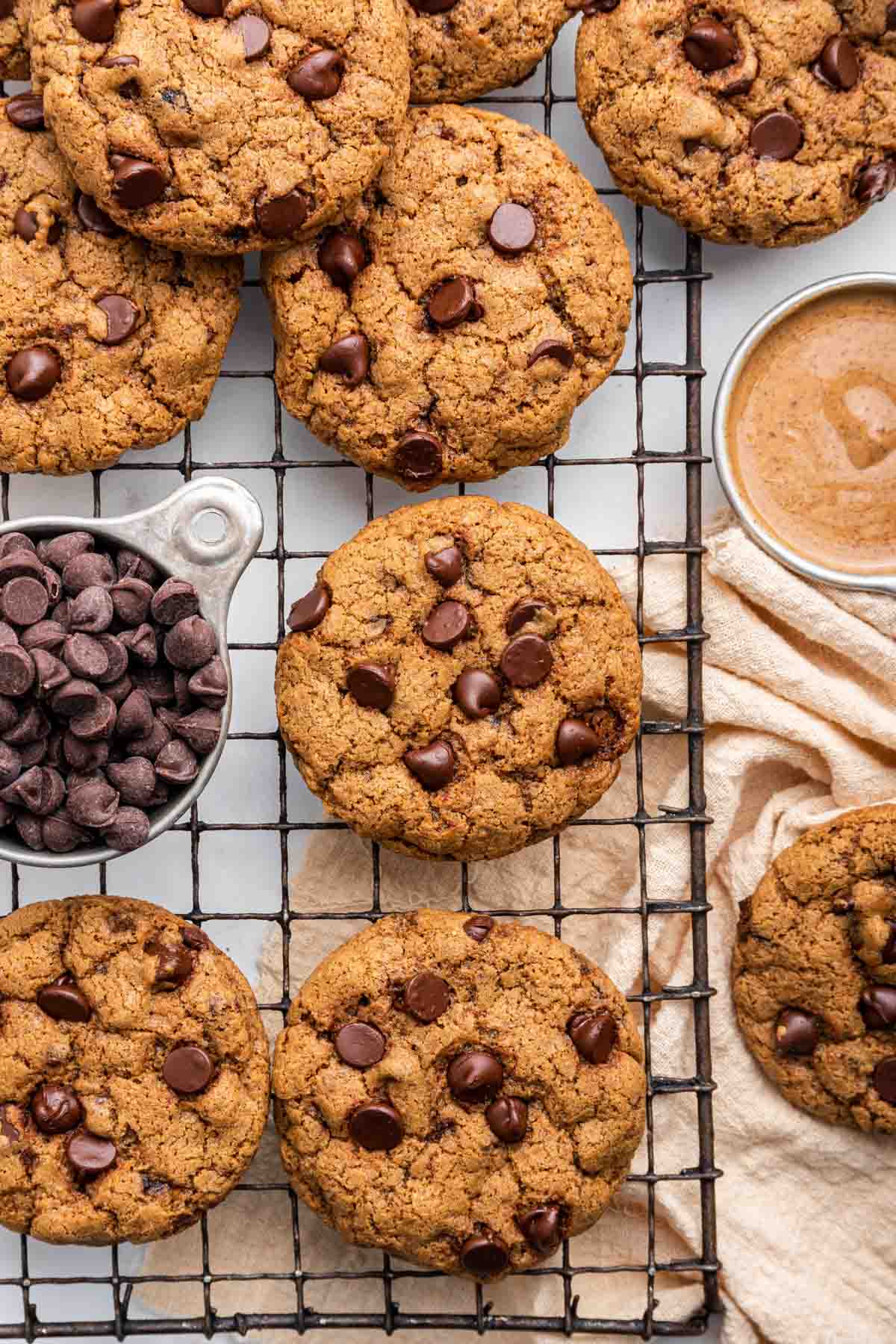 Overhead shot of almond butter chocolate chip cookies with piles of chocolate chips on the side.