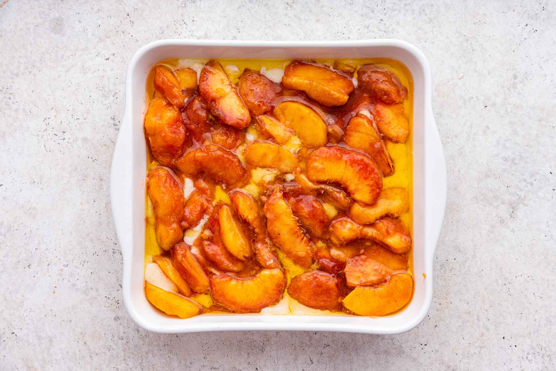 Fresh raw peaches in an 8-inch square baking dish.
