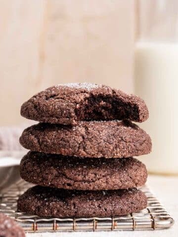 Stack of chocolate sugar cookies with bite missing from top one.