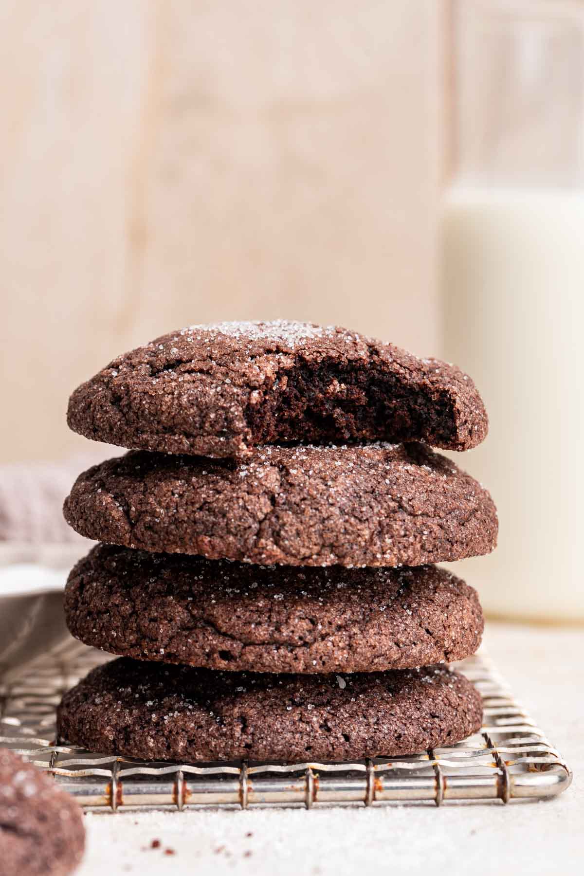 Stack of chocolate sugar cookies with bite missing from top one.