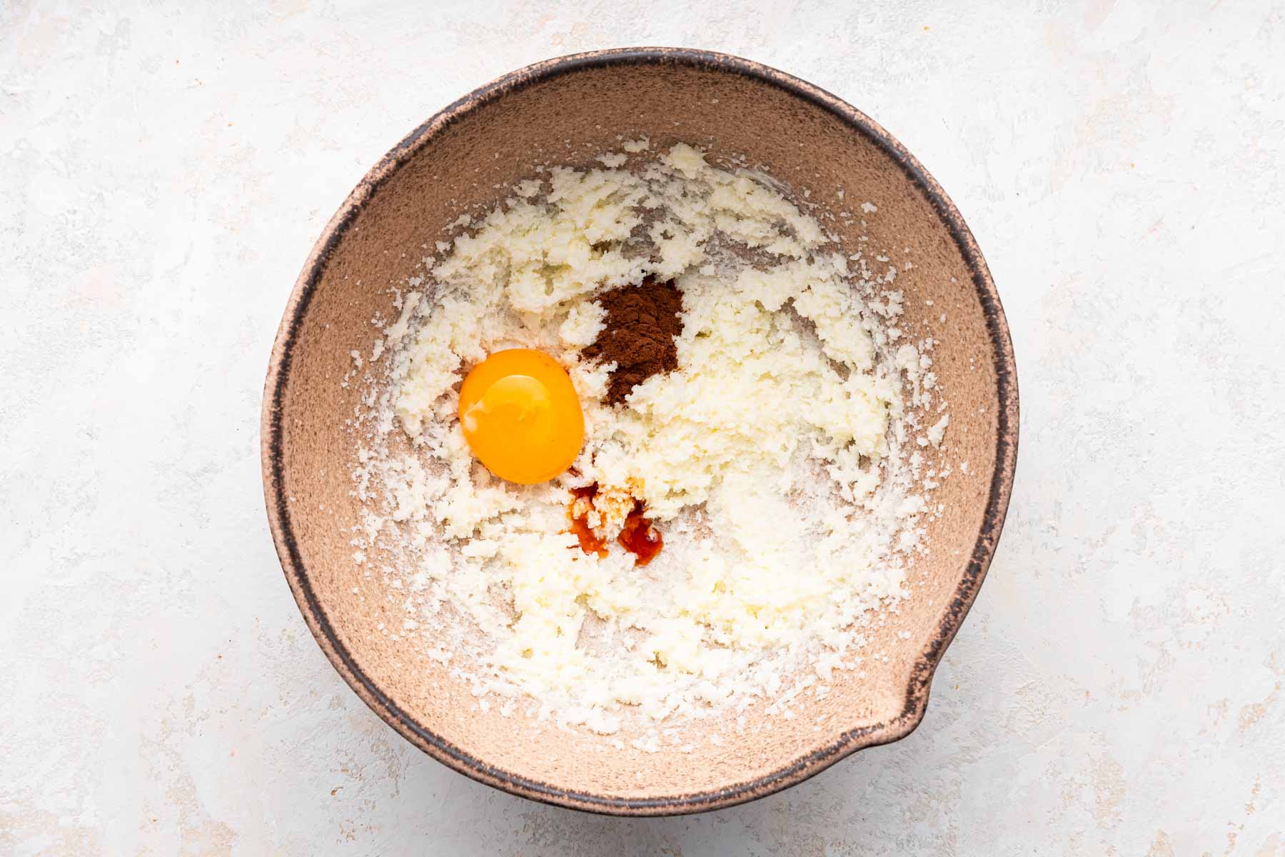 Bowl with fluffy butter, egg, vanilla and espresso powder.