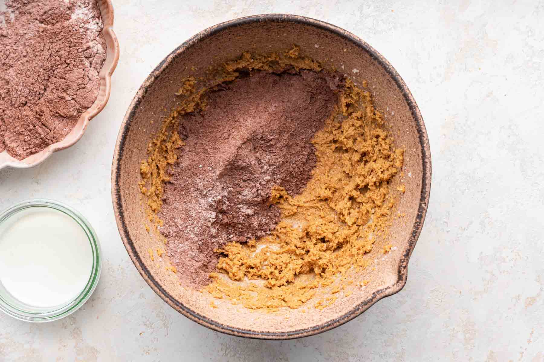 Dry cocoa powder over yellow cookie dough.