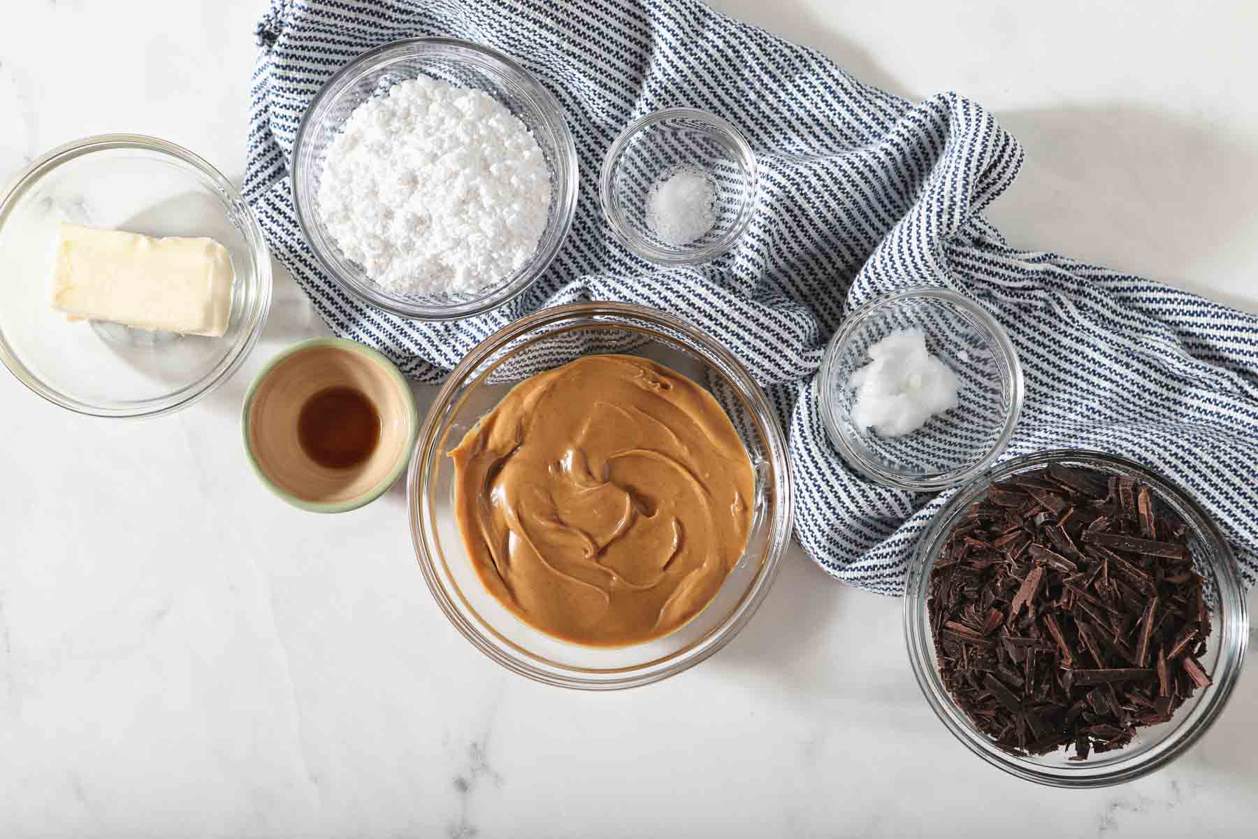 Ingredients for peanut butter truffles on white table.