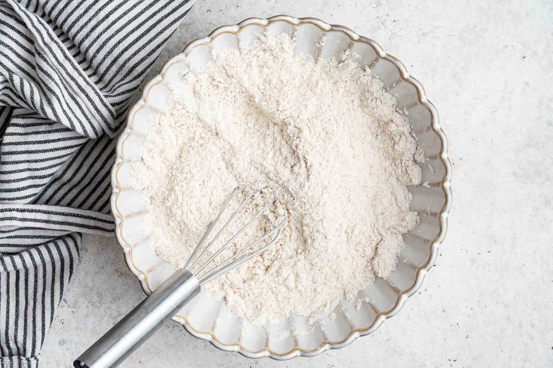 Flour, baking powder, and salt whisked in a small flower bowl.