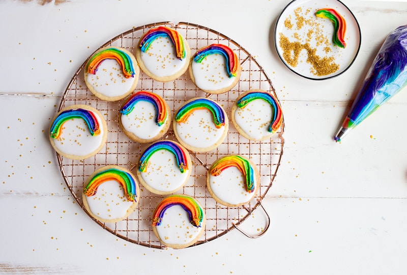Rainbow Cookies with rainbow swirl buttercream frosting and a white Royal Icing base