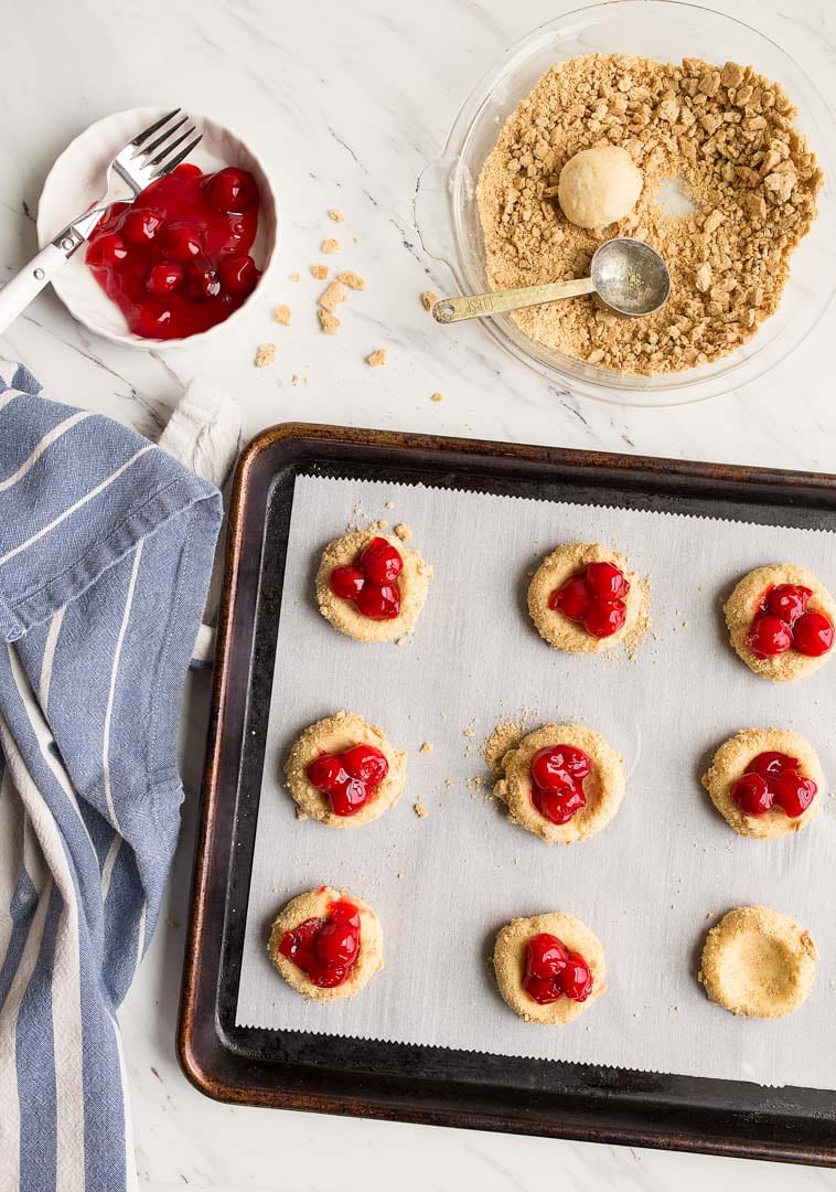 Cherry Cheesecake Cookies: cheesecake cookies rolled in graham cracker crumbs and topped with canned pie cherries.