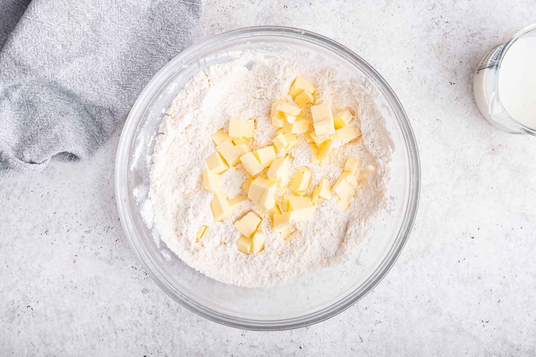 Diced butter on top of a bowl of flour.