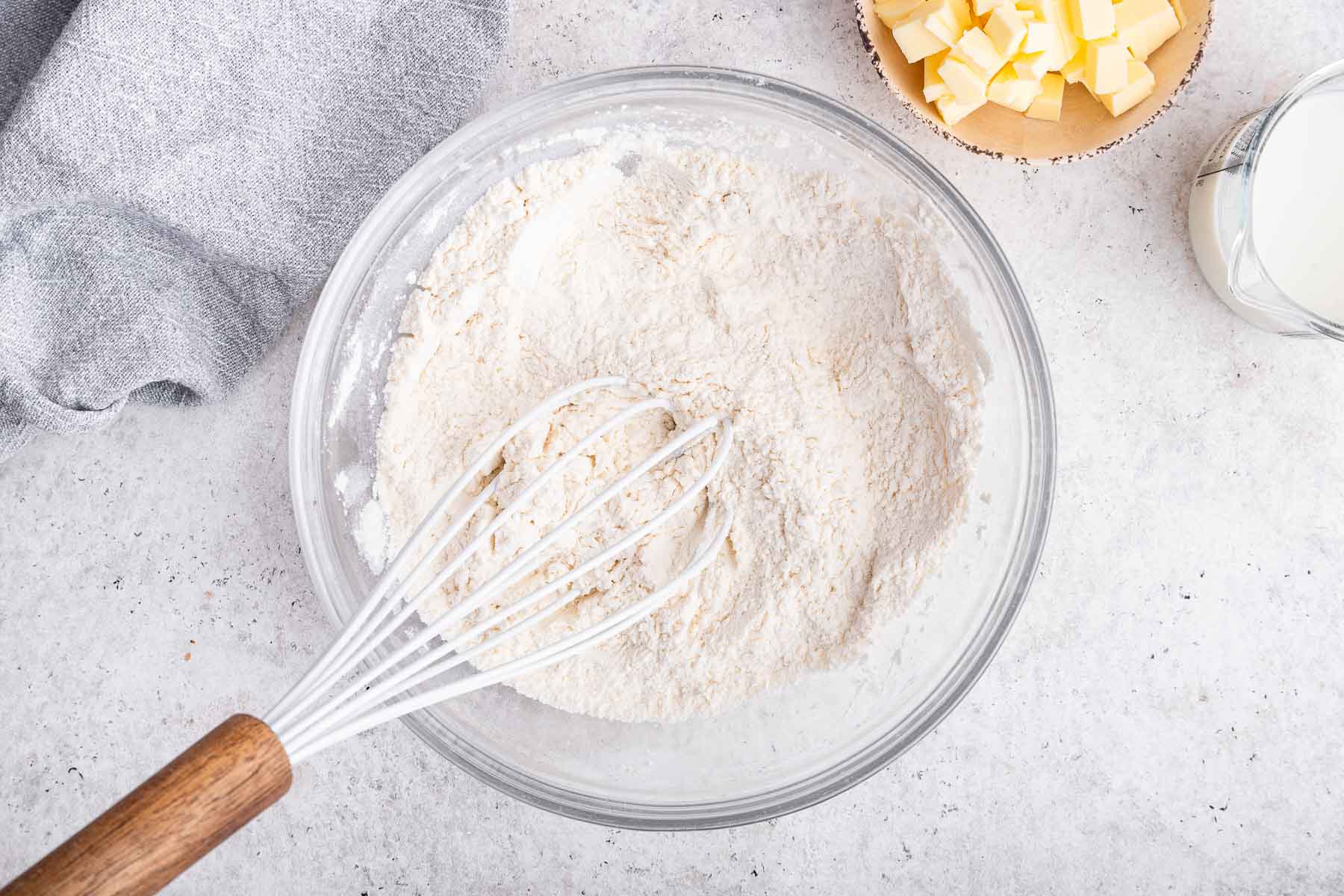 Clear bowl with flour and whisk.