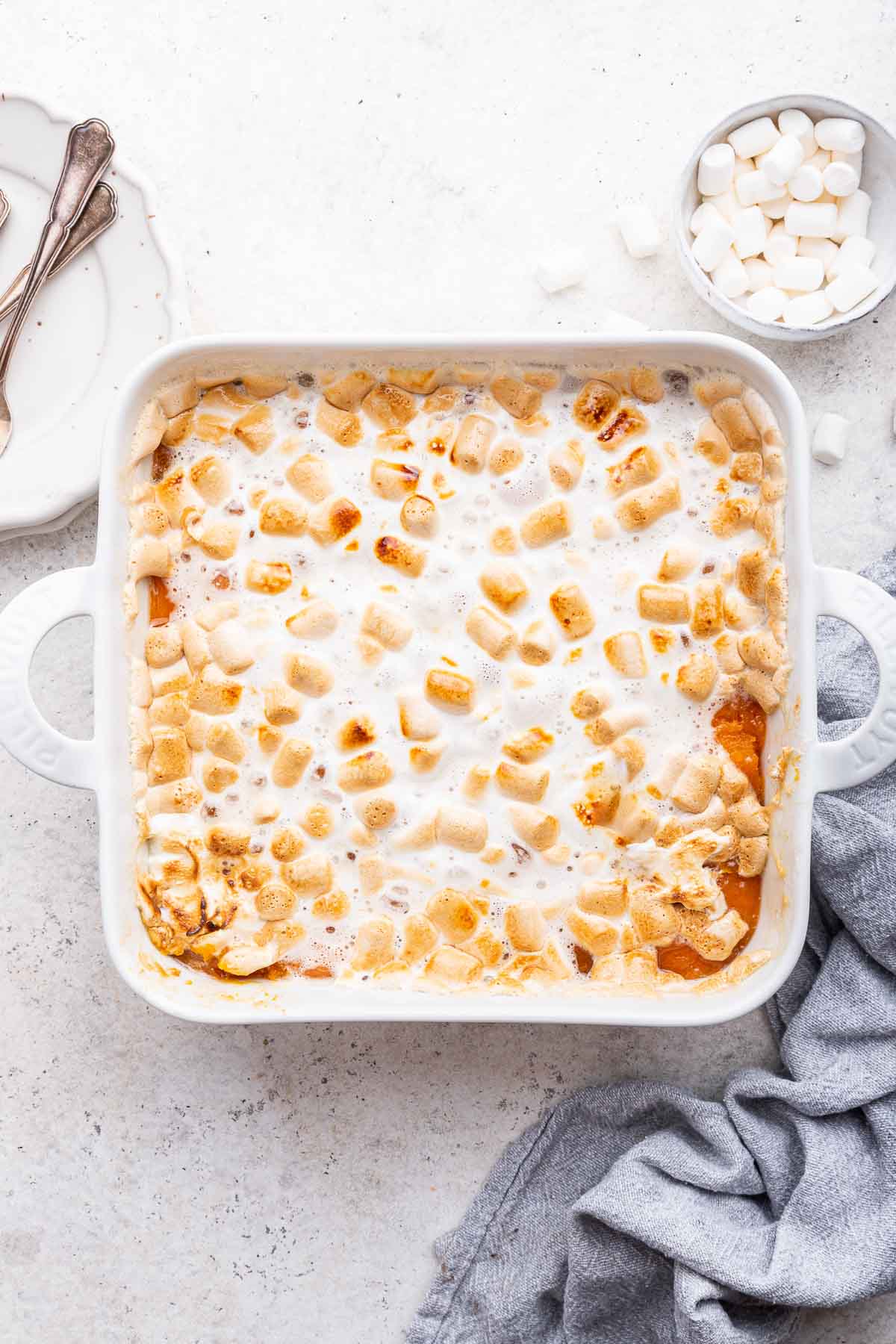 Vertical image of sweet potato casserole topped with marshmallows.