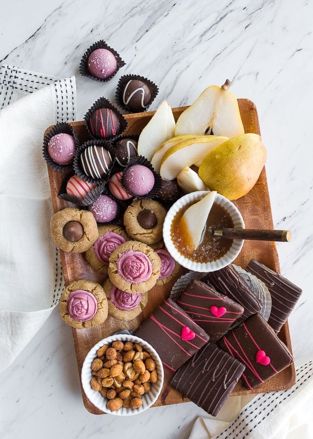 Wooden board with assorted sweets and caramel sauce.