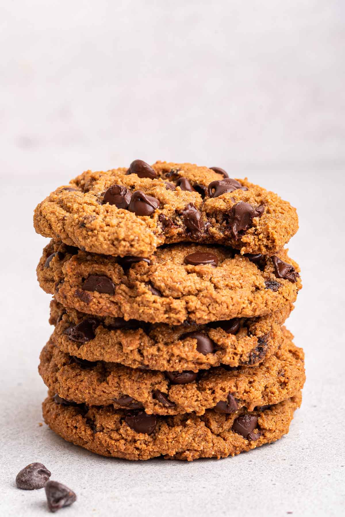 Stack of almond flour chocolate chip cookies on white counter.