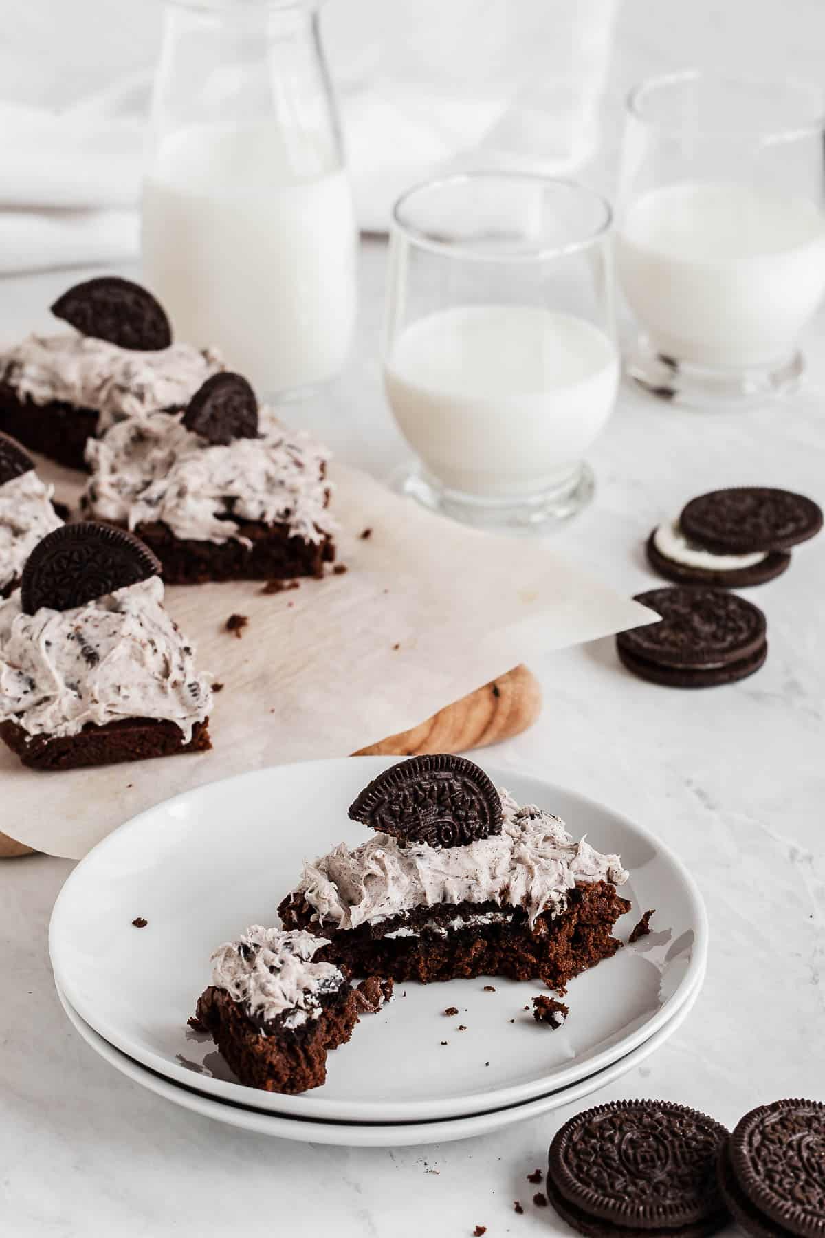 Pan of oreos cut into serving pieces with a glass of milk.