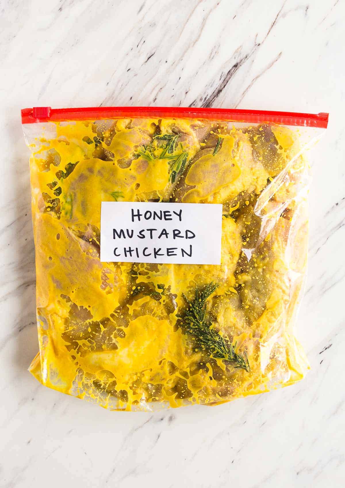 Chicken marinating in honey mustard in freezer bag.