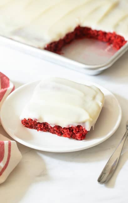 Slice of red velvet sheet cake on plate.