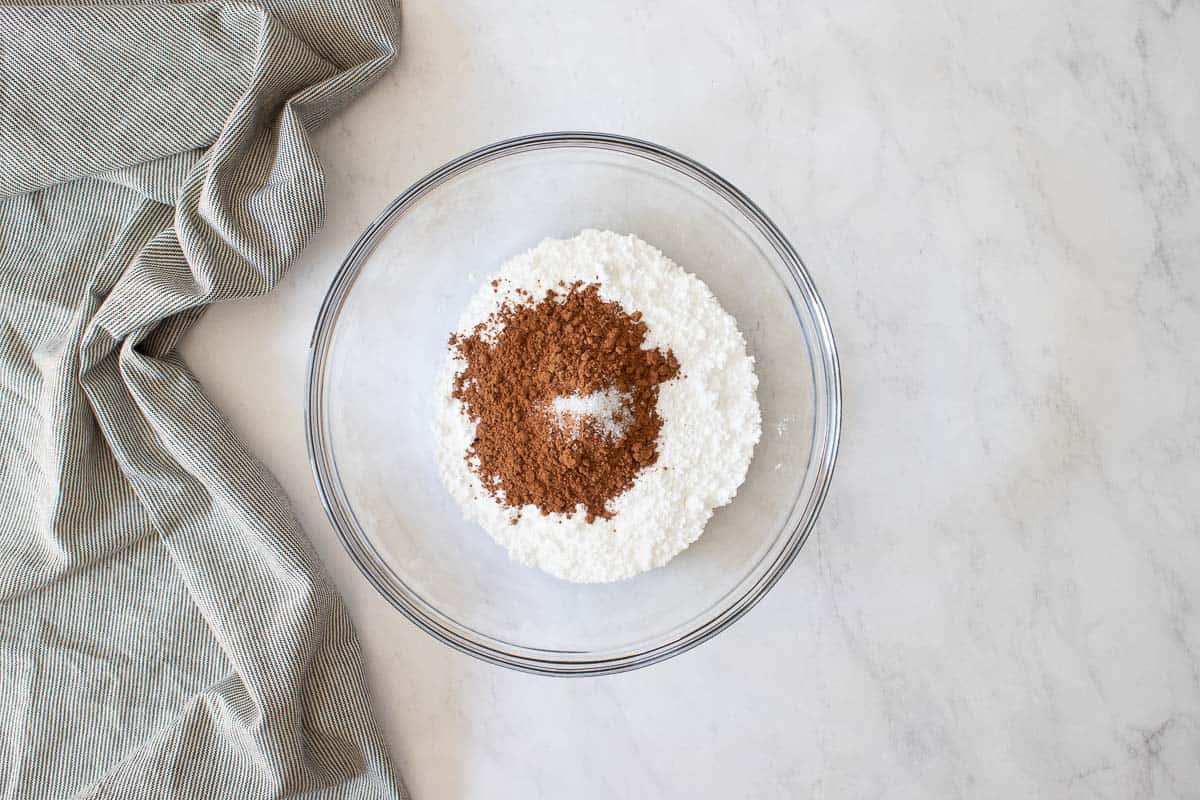 Clear glass bowl with powdered sugar and cocoa powder.