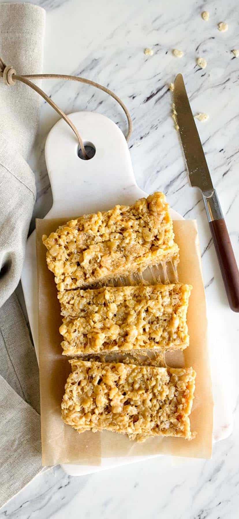 cut peanut butter rice krisipie treats on a cutting board