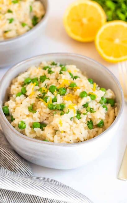 Bowl of risotto rice with peas and garnish with lemon zest.