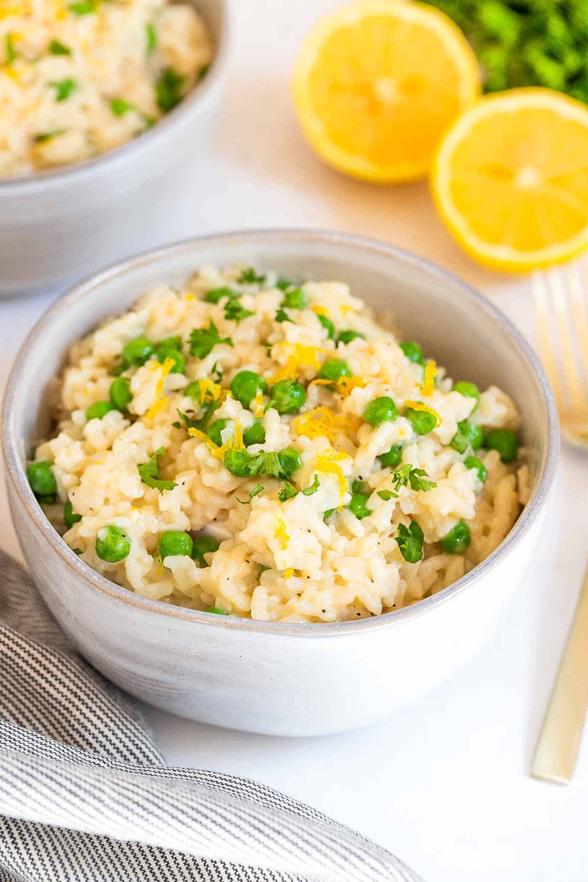Bowl of risotto rice with peas and garnish with lemon zest.
