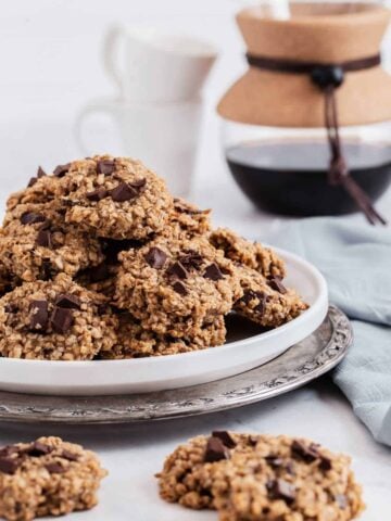 Pile of oatmeal cookies with chocolate chips on plate.