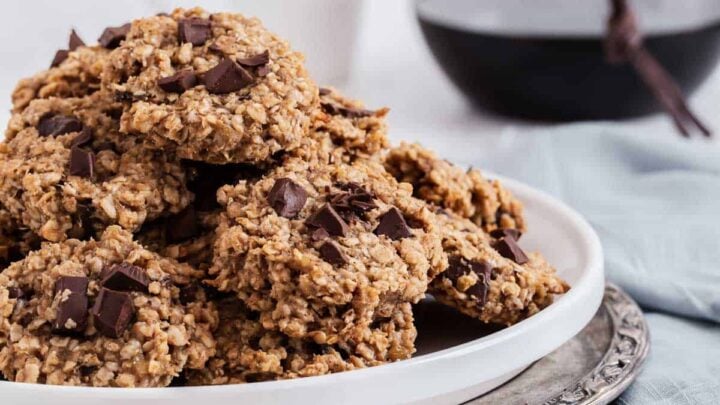 Pile of oatmeal cookies with chocolate chips on plate.