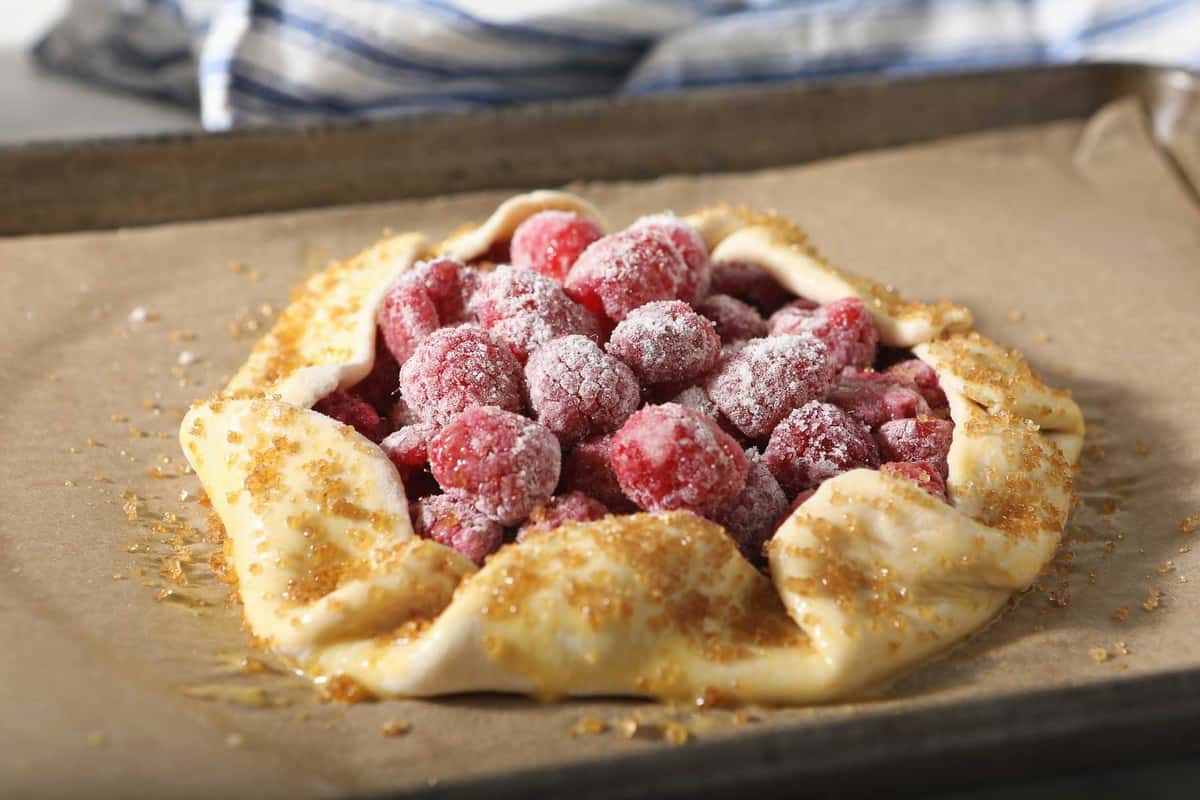 Raspberry galette on a baking sheet before going into the oven.