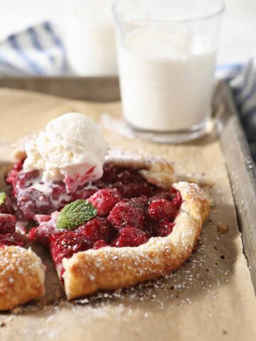 Mini raspberry galette with a scoop of ice cream and mint leaf.