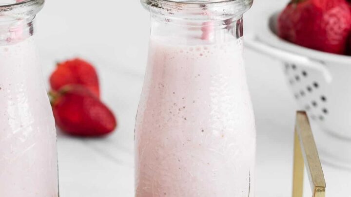 Strawberry milk in glass with straw.