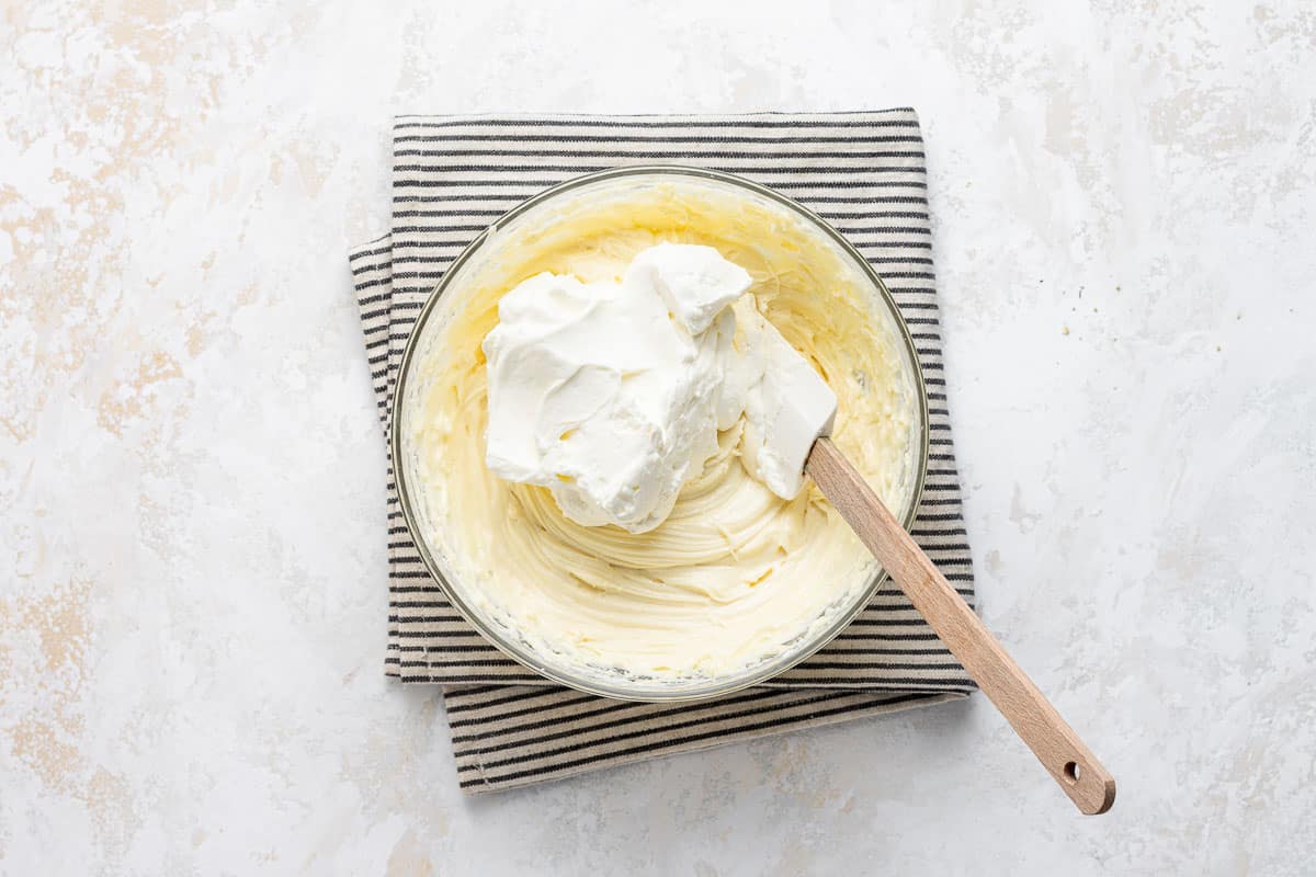 Folding whipped cream into cheesecake batter.