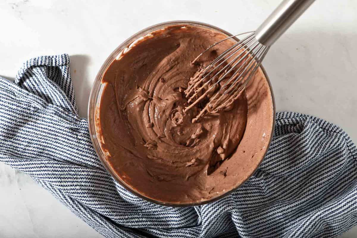 Instant chocolate pudding in a bowl with a whisk.