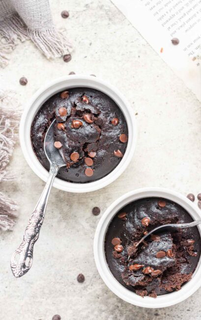 Two ramekins of microwave brownie pots with spoons.